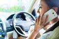 Asian woman using phone driving car