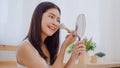 Asian woman using powder by brush make up in front mirror, Happy female using beauty cosmetics to improve herself ready to working Royalty Free Stock Photo