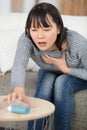 asian woman using pressurized cartridge inhaler