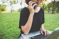 Asian woman using on smart phone and laptop with feeling relax and smiley face. Royalty Free Stock Photo