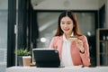 Asian Woman using smart phone for mobile payments online shopping,omni channel,sitting on table,virtual icons graphics interface Royalty Free Stock Photo