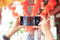 Asian woman using smart phone to take a photo of chinese new year lanterns in the china town in Royalty Free Stock Photo
