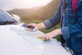 Asian woman using smartphone and map between driving car on road trip Royalty Free Stock Photo