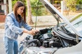 Asian woman and using smartphones to send engine pictures and send to assistance after a car breakdown on street. Concept of Royalty Free Stock Photo