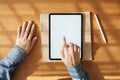 Asian woman using tablet with white screen on hand touchscreen technology item. it put on the desk and notebook