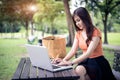 Asian woman using and typing on laptop keyboard in outdoors park Royalty Free Stock Photo