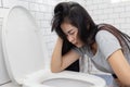 Asian Woman Vomiting into Toilet Bowl Royalty Free Stock Photo