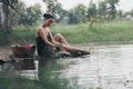 asian woman waering salong sitting on wooden bridge washing clothes in the river Royalty Free Stock Photo