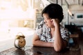 Asian woman waiting in coffee shop cafe with clock Royalty Free Stock Photo