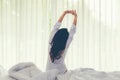 Asian women waking up stretching in bed room at home, early morning time and sunny day, vintage tone. Royalty Free Stock Photo