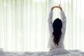 Asian women waking up stretching and raise arms in bed room at home. Royalty Free Stock Photo