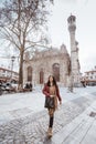 asian woman walking in the square with aziziye mosque