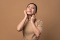 Asian woman was sick with irritate itching her skin standing on beige background