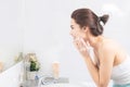 Asian woman wash her face in the bathroom before shower Royalty Free Stock Photo