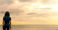 Asian woman watching sunrise sky at sea beach. Runner relax after running at tropical beach. Healthy lifestyle. Girl travel alone Royalty Free Stock Photo