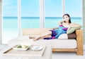Asian woman watching tv by the beach Royalty Free Stock Photo