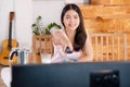 Asian woman wathcing tv on demand and use remote control change television channel at breakfast in morning Royalty Free Stock Photo