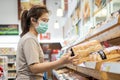 Asian woman wear face mask,choosing bread in bakery while shopping food at supermarket,people panic buying and hoarding during the