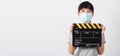 Asian woman wear face mask and hand`s holding black clapper board or movie slate or clapboard use in video production ,film, Royalty Free Stock Photo