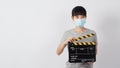 Asian woman wear face mask and hand`s holding black clapper board or movie slate use in video production ,film, cinema,movies Royalty Free Stock Photo