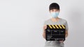 Asian woman wear face mask and hand`s holding black clapper board or movie slate use in video production ,film, cinema,movies Royalty Free Stock Photo