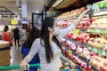 Asian woman wear face mask push shopping cart in suppermarket departmentstore. Girl, looking grocery to buy  fruit. Women wearing Royalty Free Stock Photo