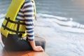 Asian woman wear life jacket sit near river, selective focus, with copy space