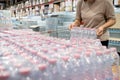 Asian woman wearing face mask,choosing packs of fresh water,beverage and food,people panic buying and hoarding during the Covid-19