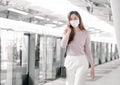 Woman wearing face mask and talking on mobile phone while standing on railway station Royalty Free Stock Photo