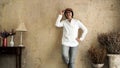 Asian woman wearing flat cap hat white shirt and jeans on vintage style sepia wall background Royalty Free Stock Photo