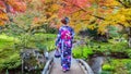 Asian woman wearing japanese traditional kimono in autumn park. Kyoto in Japan Royalty Free Stock Photo