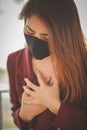 Asian woman wearing mask for protect but her with severe coughing and chest pain.