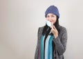 Asian woman wearing medical face mask, knitted hat and winter coat indoor. Covid-19 prevention, new normal, winter portrait