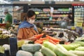 Asian woman wearing protect face mask and  shopping fruit, vegetable in grocery department store Royalty Free Stock Photo