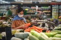 Asian woman wearing protect face mask and  shopping fruit, vegetable in grocery department store Royalty Free Stock Photo