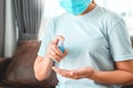 Asian woman wearing protect mask using alcohol spray disinfectant on hand to prevent spreading of the coronavirus at Home