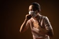Asian woman wearing protective mask for protection from virus and disease coughing standing on beige background