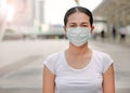 Asian woman wearing protective mask to protect virus, pollution and the flu at public area Royalty Free Stock Photo