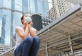 Asian woman wearing protective mask to protect virus, pollution and the flu sitting at public area Royalty Free Stock Photo