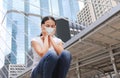 Asian woman wearing protective mask to protect virus, pollution and the flu sitting at public area Royalty Free Stock Photo