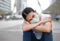 Asian woman wearing protective mask to protect virus, pollution and the flu sitting at public area Royalty Free Stock Photo