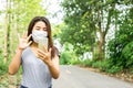 Asian woman wearing protective mask and using smart phone to video call with someone ,new normal and social distancing during covi Royalty Free Stock Photo