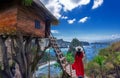 Asian woman wearing red dress visits tree house on the island of Nusa Penida, Bali, Indonesia