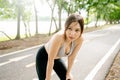 Asian woman wearing sportswear and tired engaged in fitness in public park