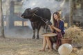 Asian woman wearing traditional thai culture,in field,vintage style listening radio on buffalo and farm background