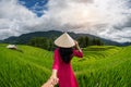 Asian woman wearing Vietnam culture traditional holding man`s hand and leading him to rice terraces in Mu Cang Chai, Yen Bai, Royalty Free Stock Photo