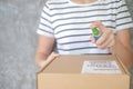 Asian woman wears mask using spray alcohol sanitizer cleaning parcel post, to prevent the virus and bacterias from postal sender,