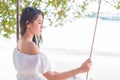 Asian woman on white dress sitting on swing at beach. People and Royalty Free Stock Photo