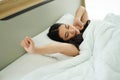 Asian woman on white pillow and bed sheet in bedroom relaxing on holiday stay home