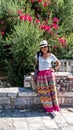 Asian woman in white t-shirt  in Athens in white hat and sarong leaning on stone wall in front of church Royalty Free Stock Photo